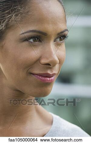 Woman smiling and looking away, portrait View Large Photo Image Picture - Woman smiling and looking away, portrait. Fotosearch
