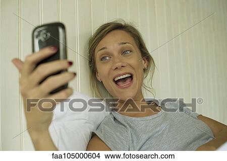 Woman smiling, taking selfie View Large Photo Image Picture - Woman smiling, taking selfie. Fotosearch