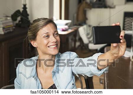 Woman taking selfie with smartphone View Large Photo Image Picture - Woman taking selfie with smartphone. Fotosearch