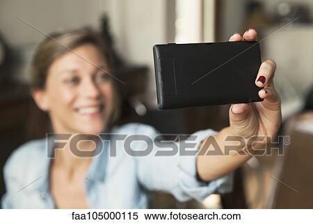 Stock Photography - Woman taking selfie with smartphone. Fotosearch