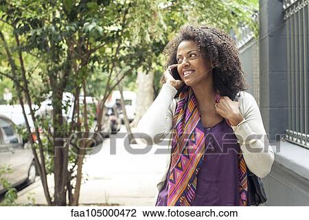 Stock Image - Woman talking on cell phone. Fotosearch