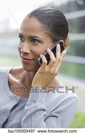 Woman using cell phone outdoors View Large Photo Image Stock Photo - Woman using cell phone outdoors. Fotosearch