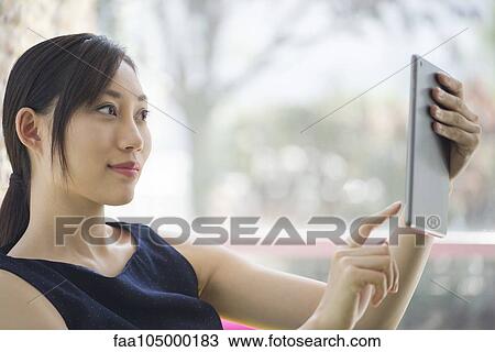 Woman using digital tablet View Large Photo Image Stock Image - Woman using digital tablet. Fotosearch