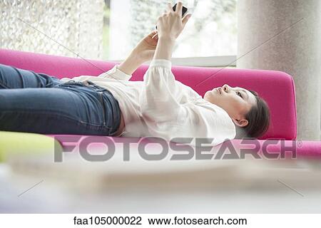 Woman watching video on smartphone at home View Large Photo Image Stock Image - Woman watching video on smartphone at home. Fotosearch