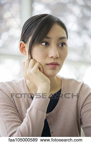Woman with hand under chin, looking away in thought View Large Photo Image Stock Photo - Woman with hand under chin, looking away in thought. Fotosearch