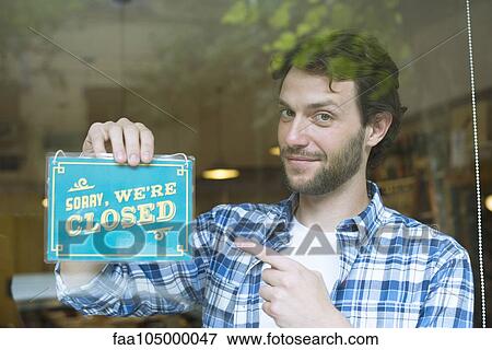Worker hanging shop closed sign View Large Photo Image Stock Photo - Worker hanging shop closed sign. Fotosearch