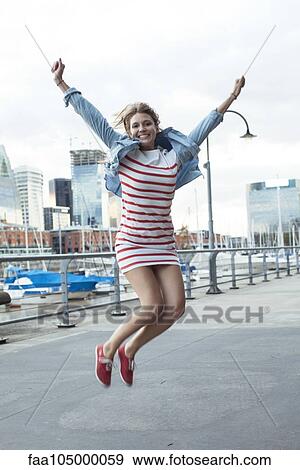 Young woman jumping for joy outdoors View Large Photo Image Stock Photo - Young woman jumping for joy outdoors. Fotosearch