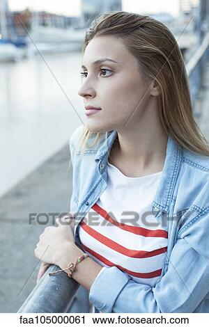 Young woman leaning against railing, looking at view of water View Large Photo Image Stock Image - Young woman leaning against railing, looking at view of water. Fotosearch