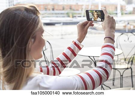Young woman posing for selfie outdoors View Large Photo Image Stock Image - Young woman posing for selfie outdoors. Fotosearch