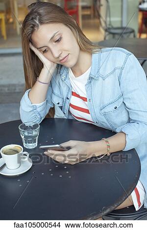 Young woman text messaging in cafe View Large Photo Image Picture - Young woman text messaging in cafe. Fotosearch