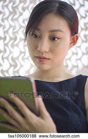Young woman using digital tablet View Large Photo Image Stock Photo - Young woman using digital tablet. Fotosearch