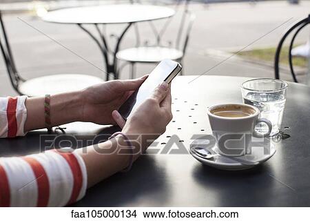 Young woman using smartphone in cafe, cropped View Large Photo Image Picture - Young woman using smartphone in cafe, cropped. Fotosearch