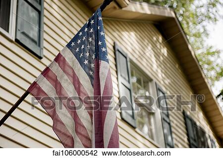 Stock Image - American flag on exterior of home. Fotosearch