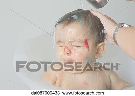 Stock Image - Baby being bathed. Fotosearch