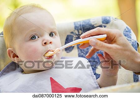 Stock Photography - Baby being fed with spoon. Fotosearch