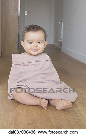 Baby sitting on floor, wrapped in a blanket, portrait View Large Photo Image Stock Photograph - Baby sitting on floor, wrapped in a blanket, portrait. Fotosearch
