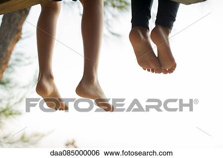 Stock Photograph - Barefoot children sitting side by side. Fotosearch