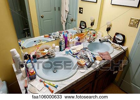 Stock Image - Bathroom sinks cluttered with health and beauty products. Fotosearch