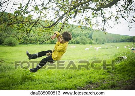 Boy having fun on rope swing View Large Photo Image Stock Image - Boy having fun on rope swing. Fotosearch