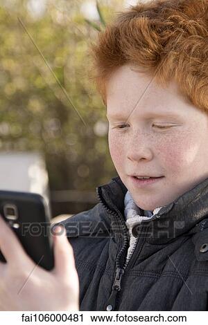 Boy using smartphone outdoors View Large Photo Image Stock Image - Boy using smartphone outdoors. Fotosearch