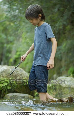 Boy wading in stream View Large Photo Image Stock Photo - Boy wading in stream. Fotosearch