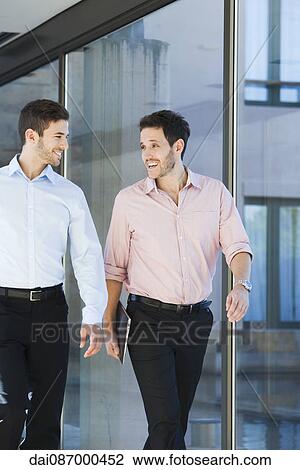 Business associates chatting while walking together View Large Photo Image Stock Image - Business associates chatting while walking together. Fotosearch