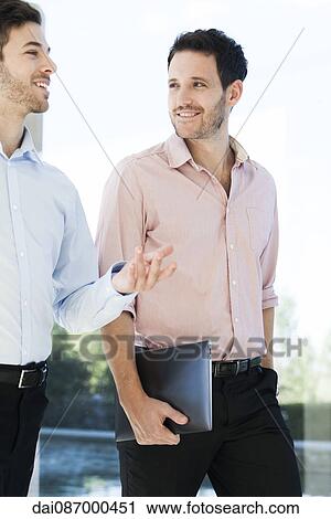 Business colleagues chatting while walking together View Large Photo Image Stock Image - Business colleagues chatting while walking together. Fotosearch