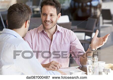 Business partners discussing work over coffee View Large Photo Image Stock Photo - Business partners discussing work over coffee. Fotosearch
