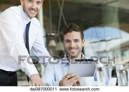Business partners working together on digital tablet View Large Photo Image Stock Image - Business partners working together on digital tablet. Fotosearch
