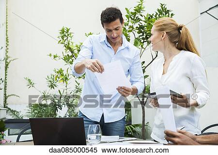 Business professionals reviewing documents View Large Photo Image Stock Photography - Business professionals reviewing documents. Fotosearch