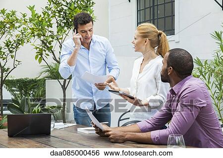 Business team collaborating View Large Photo Image Stock Photograph - Business team collaborating. Fotosearch
