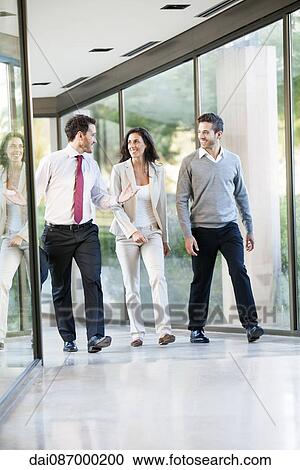 Businessman engaged in walk and talk with associates View Large Photo Image Stock Image - Businessman engaged in walk and talk with associates. Fotosearch