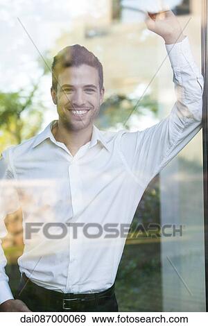 Stock Photo - Businessman looking out of window from office. Fotosearch
