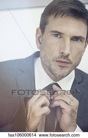 Businessman putting on tie View Large Photo Image Picture - Businessman putting on tie. Fotosearch