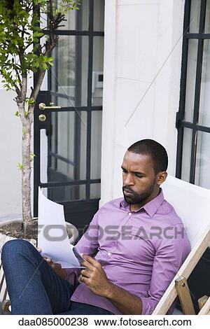 Stock Photo - Businessman reading paperwork. Fotosearch