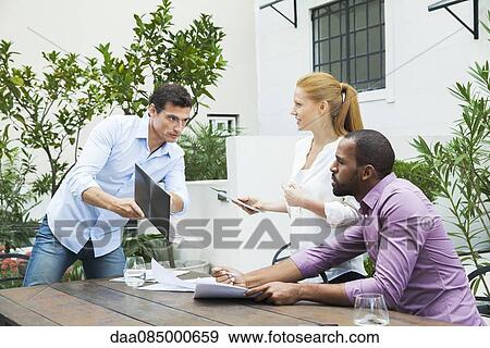 Businessman sharing good news with colleagues View Large Photo Image Stock Photo - Businessman sharing good news with colleagues. Fotosearch