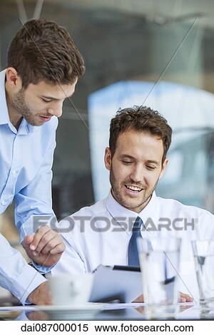 Businessman showing proposal to colleague on digital tablet View Large Photo Image Stock Photography - Businessman showing proposal to colleague on digital tablet. Fotosearch