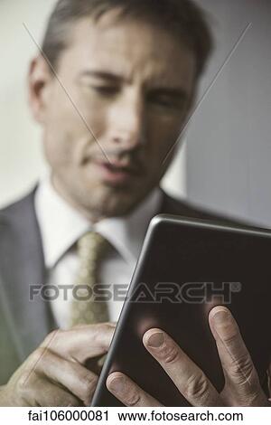 Stock Image - Businessman using digital tablet. Fotosearch