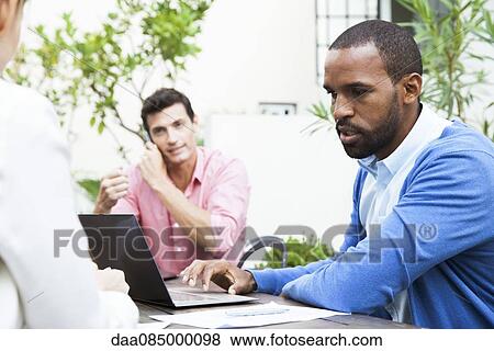 Businessman using laptop computer at meeting View Large Photo Image Stock Photo - Businessman using laptop computer at meeting. Fotosearch