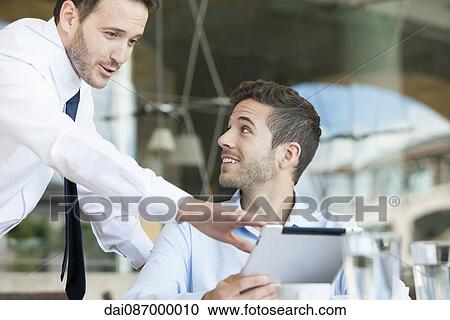 Stock Image - Businessmen collaborating project using digital tablet. Fotosearch