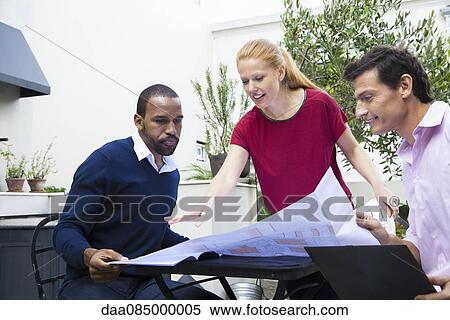 Businesswoman explaining blueprint to colleagues View Large Photo Image Stock Photography - Businesswoman explaining blueprint to colleagues. Fotosearch
