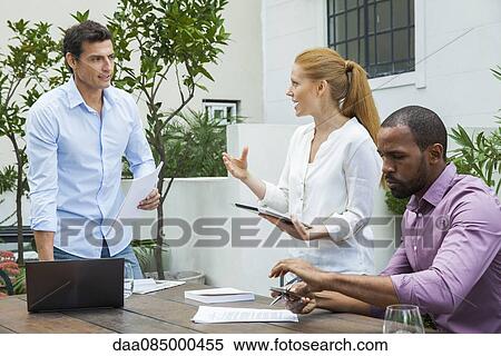 Businesswoman explaining idea to colleagues at meeting View Large Photo Image Stock Photography - Businesswoman explaining idea to colleagues at meeting. Fotosearch