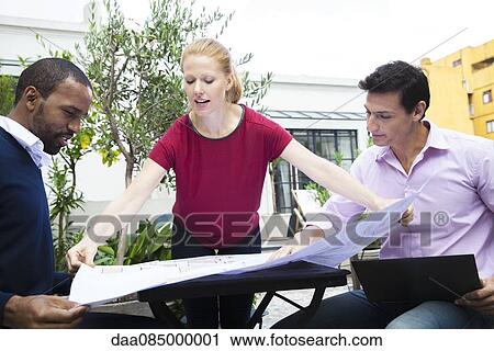Businesswoman showing colleagues blueprint View Large Photo Image Stock Image - Businesswoman showing colleagues blueprint. Fotosearch