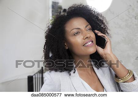 Stock Photo - Businesswoman talking on cell phone. Fotosearch