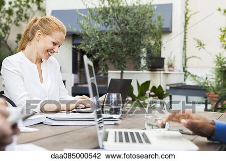 Businesswoman working with colleagues at outdoor meeting View Large Photo Image Stock Image - Businesswoman working with colleagues at outdoor meeting. Fotosearch