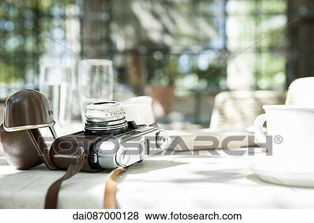 Stock Photo - Camera and cup and saucer on table. Fotosearch