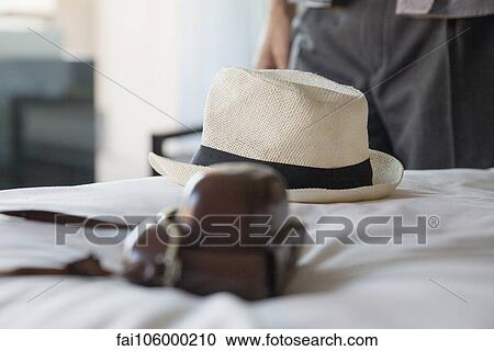 Camera and straw hat on bed in hotel room View Large Photo Image Stock Image - Camera and straw hat on bed in hotel room. Fotosearch