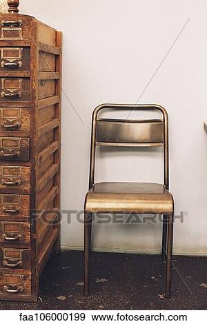 Chair next to old chest of drawers View Large Photo Image Stock Photo - Chair next to old chest of drawers. Fotosearch