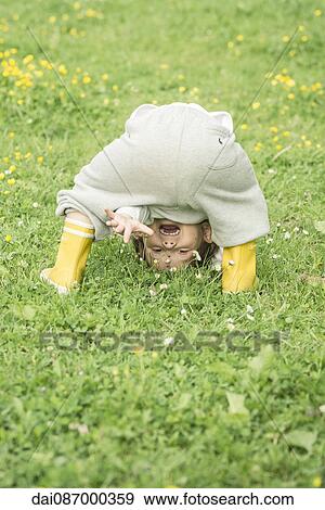 Child bending over, waving through legs View Large Photo Image Stock Photo - Child bending over, waving through legs. Fotosearch