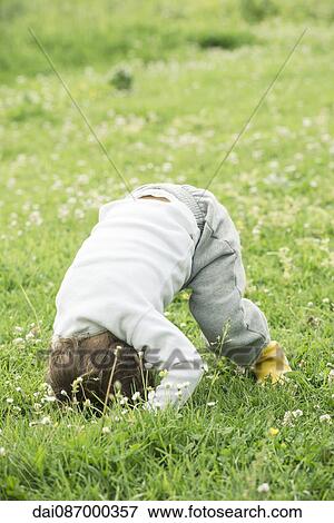 Stock Photo - Child doing somersault in grass. Fotosearch